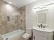Well-lit bathroom with a shower over bathtub, decorative vanity, and neutral tile, offering a clean and inviting space at 725 Riley Pl, Atlanta, GA 30327