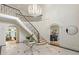 Grand foyer with a curved staircase, marble floors, and an elegant chandelier at 725 Riley Pl, Atlanta, GA 30327