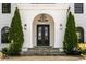 Grand entrance featuring a black wrought-iron double door, stone steps, and manicured evergreens at 725 Riley Pl, Atlanta, GA 30327
