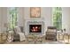 Cozy living room with fireplace, armchairs, and large windows offering stunning views at 725 Riley Pl, Atlanta, GA 30327