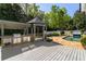 Outdoor kitchen with built-in grill and gazebo overlooking stone patio and pool with waterfall feature at 725 Riley Pl, Atlanta, GA 30327
