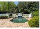 Backyard pool with stone tile surround and a decorative fountain against a backdrop of lush greenery at 725 Riley Pl, Atlanta, GA 30327