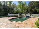 Backyard swimming pool with waterfall feature and stone patio, surrounded by lush landscaping at 725 Riley Pl, Atlanta, GA 30327