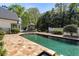 Backyard swimming pool with stone patio and lush landscaping creating a private oasis at 725 Riley Pl, Atlanta, GA 30327