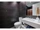 Modern bathroom with dark tile, a large mirror, and sleek, minimalist fixtures at 1276 Edmund Ne Ln, Brookhaven, GA 30319