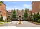 View of elegant townhomes behind wrought-iron gates and mature trees at 1276 Edmund Ne Ln, Brookhaven, GA 30319