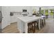 Open-concept kitchen featuring a large island with seating, modern stainless appliances, and sleek white cabinetry at 1407 Bluffs Ridge Way, Canton, GA 30114