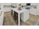 Spacious kitchen featuring a large center island with seating, stainless steel appliances, and wood-style flooring at 1407 Bluffs Ridge Way, Canton, GA 30114