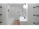 Bathroom featuring black hardware, white vanity and tile, and combo tub/shower at 2610 Knoll Se Rd, Smyrna, GA 30080