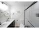 Modern bathroom with double sink vanity, white marble walls, toilet, and glass shower with black trim at 2610 Knoll Se Rd, Smyrna, GA 30080
