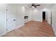 Bedroom showcasing hardwood flooring, modern ceiling fan, inset electric fireplace, and three access doors at 2610 Knoll Se Rd, Smyrna, GA 30080
