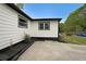 Home exterior featuring white siding, dark trim, garden beds, and a concrete patio at 2610 Knoll Se Rd, Smyrna, GA 30080