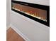 Modern electric fireplace with rock detail, recessed into the wall, with warm lighting at 2610 Knoll Se Rd, Smyrna, GA 30080