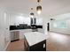 Stylish white kitchen with black backsplash, island, stainless steel appliances, and modern lighting at 2610 Knoll Se Rd, Smyrna, GA 30080