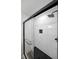 Walk-in shower with hexagon tile floor, rain shower head, glass doors, and built-in marble tiled niche at 2610 Knoll Se Rd, Smyrna, GA 30080