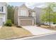 Tan two-story home with a two-car garage and a tidy front yard with fresh mulch at 275 Denver Ave, Hiram, GA 30141