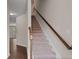 Carpeted staircase with wooden handrail leads to the upper level, with wood floors on first floor at 275 Denver Ave, Hiram, GA 30141
