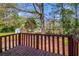 A backyard deck with wood railings presents outdoor living space surrounded by lush greenery at 3742 Linecrest Rd, Ellenwood, GA 30294