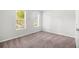 Bedroom featuring neutral carpeting and two windows, creating a bright and airy space at 3742 Linecrest Rd, Ellenwood, GA 30294