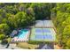 Aerial view of community pool and tennis courts surrounded by lush trees at 4735 Longcourt Se Dr, Atlanta, GA 30339