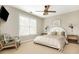 Neutral bedroom features an updated ceiling fan, large window, and a comfortable chair at 4735 Longcourt Se Dr, Atlanta, GA 30339