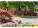 Landscaped entrance to the Longleaf community in Vinings features a stone retaining wall and flowering plants at 4735 Longcourt Se Dr, Atlanta, GA 30339