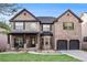 Charming two-story brick home with a well-manicured lawn and inviting front porch at 1023 Bentley Estates Dr, Dacula, GA 30019