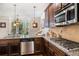 Close-up of a gourmet kitchen with granite counters, stainless appliances, and dark wood cabinetry at 1023 Bentley Estates Dr, Dacula, GA 30019