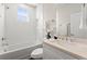 Bright bathroom featuring a tub-shower, window, and vanity with a light countertop at 1123 W Marietta St, Atlanta, GA 30318