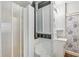 All-white bathroom with floral wallpaper, glass block window, and a step-in shower at 1711 Homestead Ne Ave, Atlanta, GA 30306