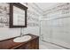 Full bathroom with vanity, mirror, sink, tub and shower combo with glass doors and unique wallpaper at 1711 Homestead Ne Ave, Atlanta, GA 30306