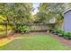 Backyard with a small lawn, a wood fence, and an outbuilding surrounded by mature trees at 327 6Th Ne St, Atlanta, GA 30308