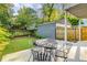 View of a backyard patio deck with mature trees, an outdoor dining table, and a fenced-in yard at 327 6Th Ne St, Atlanta, GA 30308