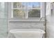Bright bathroom features a glass enclosed shower, soaking tub, and double windows at 327 6Th Ne St, Atlanta, GA 30308