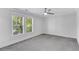 A well-lit, carpeted bedroom with large windows and a ceiling fan at 327 6Th Ne St, Atlanta, GA 30308
