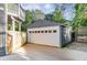 Detached garage with a white door and gray trim provides secure parking and additional storage space at 327 6Th Ne St, Atlanta, GA 30308