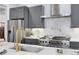 This kitchen has a stainless steel stove, white backsplash, gray cabinets and gold hardware at 327 6Th Ne St, Atlanta, GA 30308