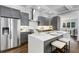 This kitchen has gray cabinets, stainless steel appliances, a large island and hardwood flooring at 327 6Th Ne St, Atlanta, GA 30308