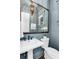 Stylish powder room with pedestal sink, decorative mirror, and soothing blue walls at 327 6Th Ne St, Atlanta, GA 30308