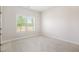 Minimalist bedroom with carpet, a white wall, and a window to view the landscape outside at 1600 Kamp Springs Ave, Lawrenceville, GA 30045