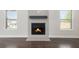 Bright living room featuring a fireplace with a dark mantel and sleek hardwood floors at 1600 Kamp Springs Ave, Lawrenceville, GA 30045