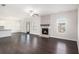 Open living room featuring a cozy fireplace, large windows, and hardwood flooring at 1600 Kamp Springs Ave, Lawrenceville, GA 30045