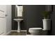 Stylish powder room featuring a pedestal sink, modern fixtures, and elegant wood-look flooring at 2450 Cotton Ln, Douglasville, GA 30135