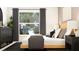 Comfortable bedroom featuring a large window, stylish decor, and a queen-sized bed with decorative pillows at 2450 Cotton Ln, Douglasville, GA 30135