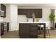 A modern kitchen featuring dark cabinets, a center island with seating, and stainless steel appliances at 2450 Cotton Ln, Douglasville, GA 30135