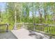 This spacious wooden deck is surrounded by tall, mature trees for plenty of shade and privacy at 639 Ladora Dr, Dallas, GA 30157