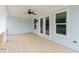 Cozy covered porch with ceiling fan, natural wood flooring, and view of greenery at 6585 Rhett Run, Cumming, GA 30028