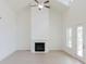 Bright living room features high ceilings, a ceiling fan, fireplace, and a door to the outside at 6585 Rhett Run, Cumming, GA 30028