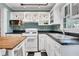 Bright kitchen with white cabinets, black countertops, gas range, and checkerboard floors at 108 Glenn St, Decatur, GA 30030
