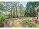 Landscaped backyard with a wooden fence and mature trees and shrubs at 206 Mountain Vista Blvd, Canton, GA 30115